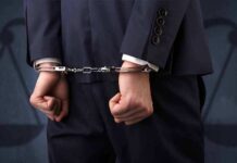 Mental Health Loophole Saves Cop? Businessperson in handcuffs with hands behind back