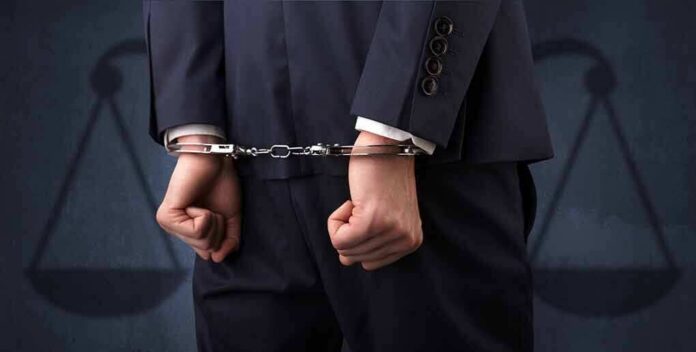 shutterstock_1104042224 Businessperson in handcuffs with hands behind back