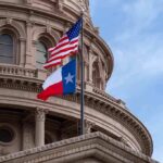 Texas and U.S. flags in front of a capitol building dome