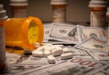 Taxpayer Bleed Stopped? $2.2B on Hold Prescription pill bottle and white tablets on scattered US dollar bills