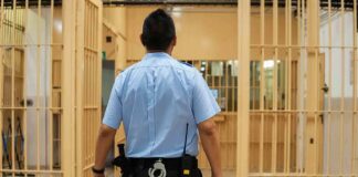 corrections officer walking through prison corridor