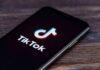 TikTok Curfew: $100M And A Catch smartphone displaying the TikTok app logo on screen