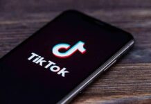 TikTok Curfew: $100M And A Catch smartphone displaying the TikTok app logo on screen
