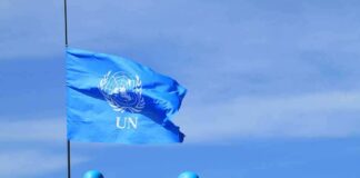 UN flag above peacekeepers in blue helmets