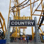 Upside-Down Chaos Sparks Big Payout roller coaster entrance with large sign and yellow track