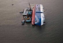 Horror At Sea – Bodies Keep Coming Capsized cargo ship with salvage vessels alongside