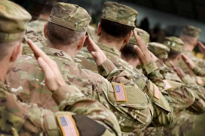 shutterstock_1548712049 Soldiers in camouflage uniforms saluting