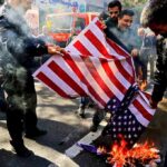 Trump Demands Trials Over Iran Crackdown people burning a U.S. flag on a city street