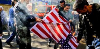 people burning a U.S. flag on a city street