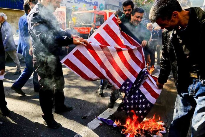 shutterstock_1609051222 people burning a U.S. flag on a city street