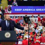 Trump Makes Final Push For GOP Candidate Crowd at a political rally with a speaker at a podium; Stephen Paea, Curtis Lofton, Walter Jones, John Sullivan, and Colin David Jones present