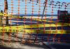 Orange safety net and yellow police tape blocking a beach access