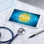 Fauci’s Two-Tone Message Fuels Outrage Tablet with FDA on screen amid medical tools and ECG charts