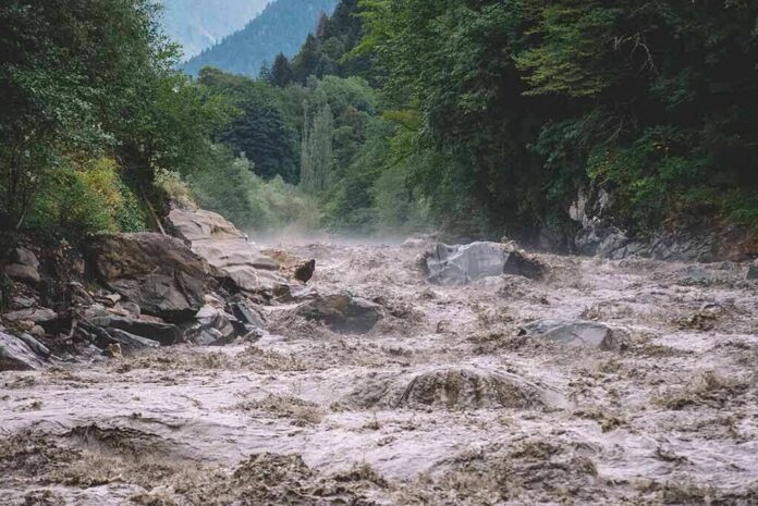 shutterstock_1732590473-1 Flooded river gorge with fast muddy water and rocks