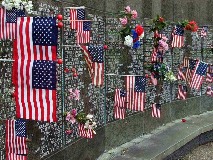 shutterstock_17555125 Memorial wall adorned with American flags and flowers
