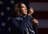 Harris Pushes Global AI Handcuffs Woman speaking on stage with microphone