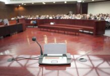 Staff Affairs Claim Explodes In Congress Conference microphone on a podium in a courtroom