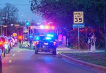 Red Light Run Ends In Tragedy Emergency vehicles with flashing lights on a city street at night