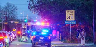 Emergency vehicles with flashing lights on a city street at night