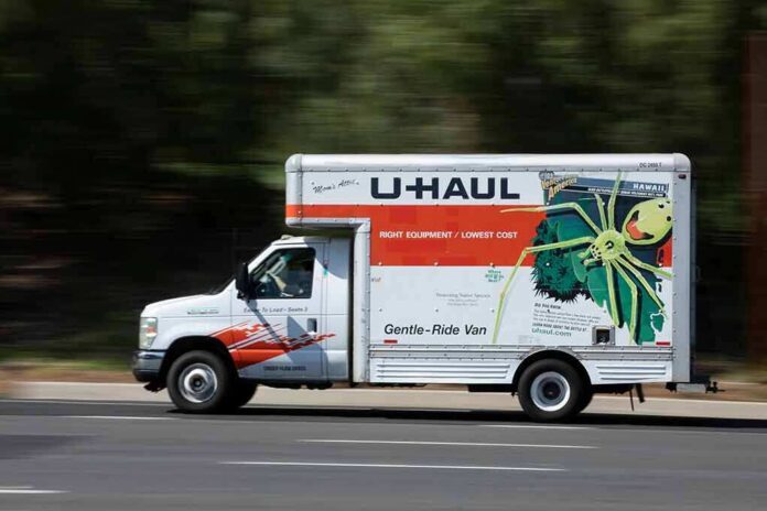 shutterstock_1963257061 U-Haul moving truck driving on a road
