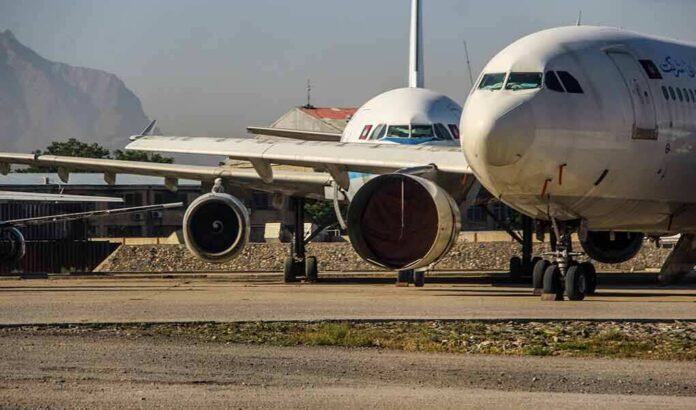 Parked passenger aircraft with covered engines on a tarmac
