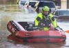 High Tide Danger Puts NYC On Edge Rescue worker in an inflatable boat during urban flooding