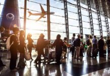 Panic Spike Halts Miami Airport Passengers queue inside an airport terminal at sunset