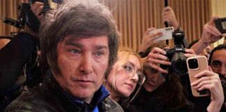 Man surrounded by reporters with cameras and phones