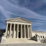 Supreme Court building with grand columns under a blue sky