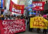 DSA Surge Rattles 2026 Primaries Protesters holding large banners at a city street demonstration