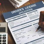 Driver's license application form being filled out by hand