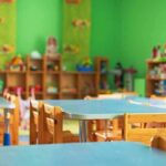 Preschool classroom with small tables and wooden chairs