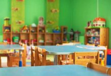 Preschool classroom with small tables and wooden chairs