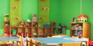 Preschool classroom with small tables and wooden chairs