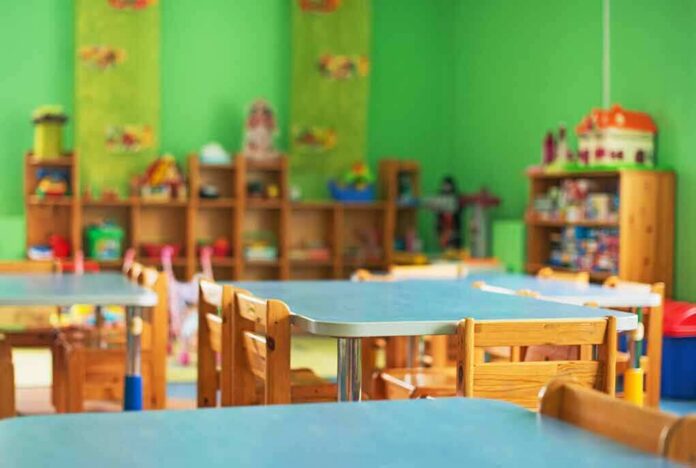 Preschool classroom with small tables and wooden chairs