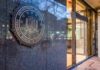 Enemies List Bombshell Hits FBI Chief FBI emblem on a stone wall beside a glass entrance