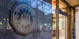 FBI emblem on a stone wall beside a glass entrance