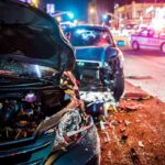 Wrecked cars at night crash scene with police lights