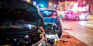 Wrecked cars at night crash scene with police lights