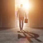 Jeffries’ Quiet Meeting Ignites Left Fury Businessman walking toward bright city doorway with briefcase