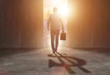 Jeffries’ Quiet Meeting Ignites Left Fury Businessman walking toward bright city doorway with briefcase