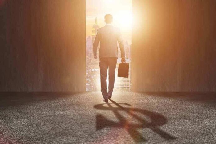shutterstock_744434371 Businessman walking toward bright city doorway with briefcase