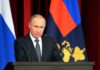 Putin Hand-Off Sparks Daring U.S. Win Vladimir Putin speaking at a podium with microphones