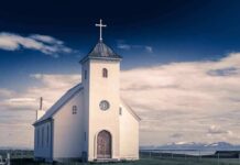 House Of Worship Bomb Plot Unveiled White countryside church with steeple and cross under a dramatic sky