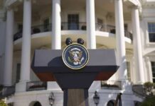 Five-Day Freefall At The Podium Presidential podium with seal in front of white-columned building