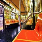 Empty subway car with orange seats and open doors