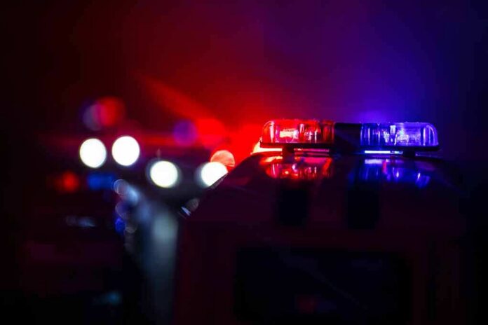shutterstock_1191163906 Police car light bar flashing red and blue at night