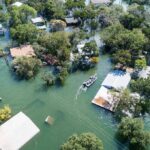 Aerial view of flooded neighborhood with rescue boat navigating streets