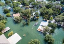 Life-Threatening Waves Slam Southern California Aerial view of flooded neighborhood with rescue boat navigating streets