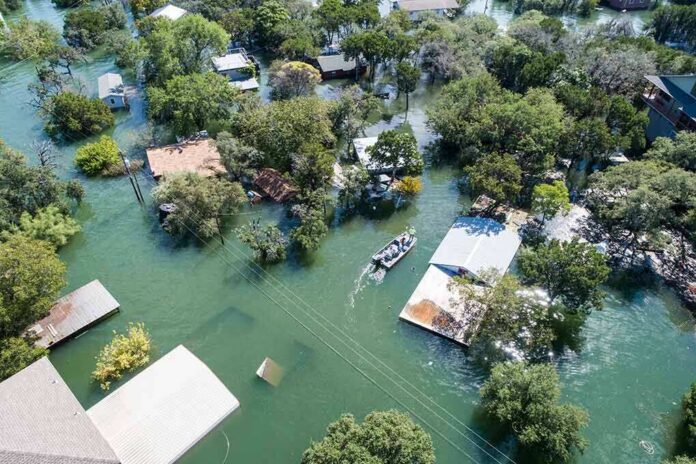 shutterstock_1213793479 Aerial view of flooded neighborhood with rescue boat navigating streets